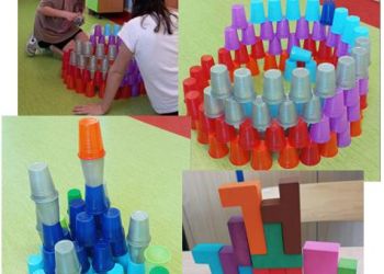 Powiększ zdjęcie: Układanie budowli z kolorowych kubków i drewnianych klocków.