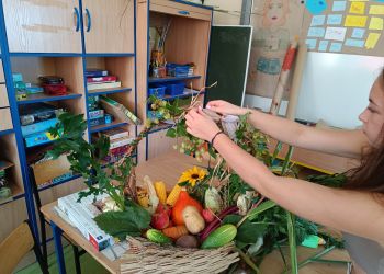 Powiększ zdjęcie: Uczennica dekoruje kosz jaworzańską roślinnością.