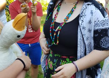 Powiększ zdjęcie: Wychowankowie w strojach dożynkowych z kompozycjami z kukurydzy - myszkami, pszczołami.