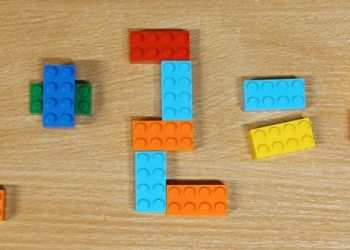 Powiększ zdjęcie: Łamigłówka zbudowana z trzech zestawów klocków LEGO - 2 + 2 = 4.