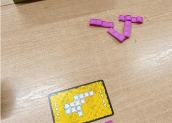 Powiększ zdjęcie: Uczniowie budują wzór pokazany na karcie z trójwymiarowych, prostokątnych klocków - utrwalają własnosci brył i figur geometrycznych.