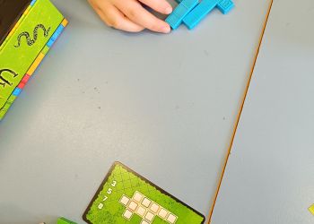 Powiększ zdjęcie: Uczniowie grają w gry planszowe dotyczące układania brył według wzoru.