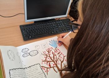 Powiększ zdjęcie: Uczennica wykonuje lapbook pt.: „Liczby i działania w życiu codziennym”.
