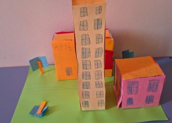 Powiększ zdjęcie: Projekt miasta przedstawiający domy, blok, aptekę i ulicę.