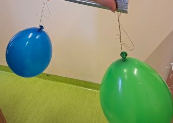 Powiększ zdjęcie: Baloniki powieszone na nitkach, tak aby się nie stykały. Potarte energicznie kawałkiem tkaniny - baloniki się odpychają.