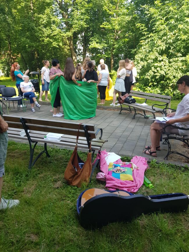 Dzieci i dorośli tworzący rzeźby z wykorzystaniem kolorowych tkanin