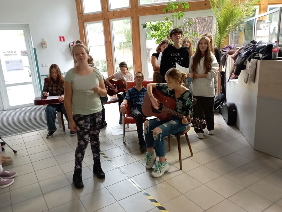 Młodzież śpiewa i gra na gitarach