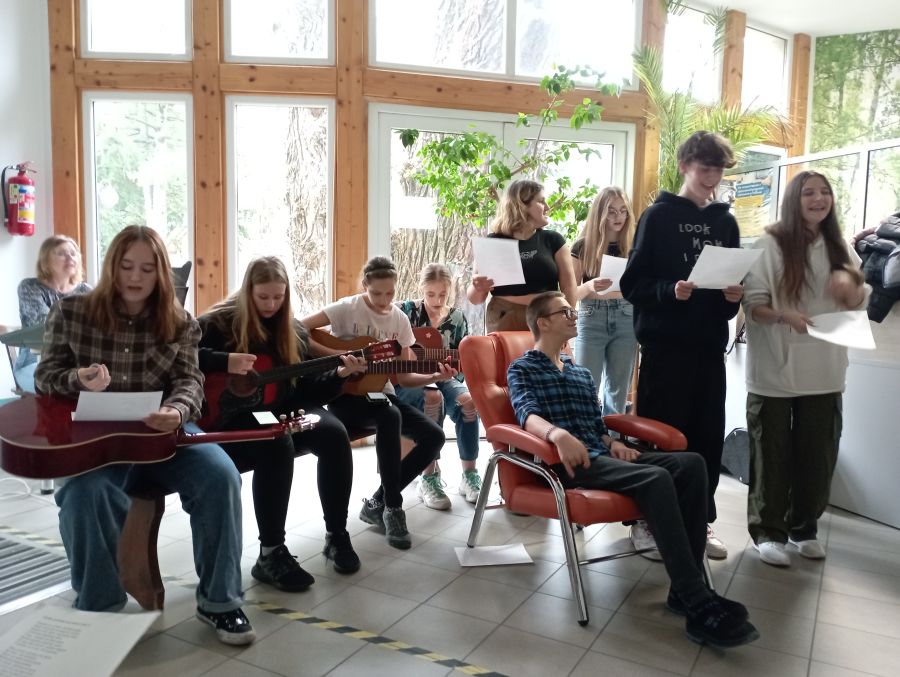 Młodzież śpiewa i gra na gitarach