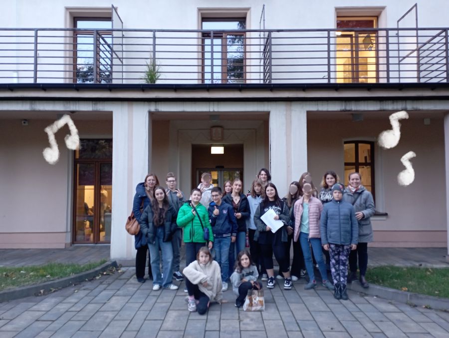 Zdjęcie grupowe występujących osób, w tle budynek Oddziału dla dorosłych BZL-Z