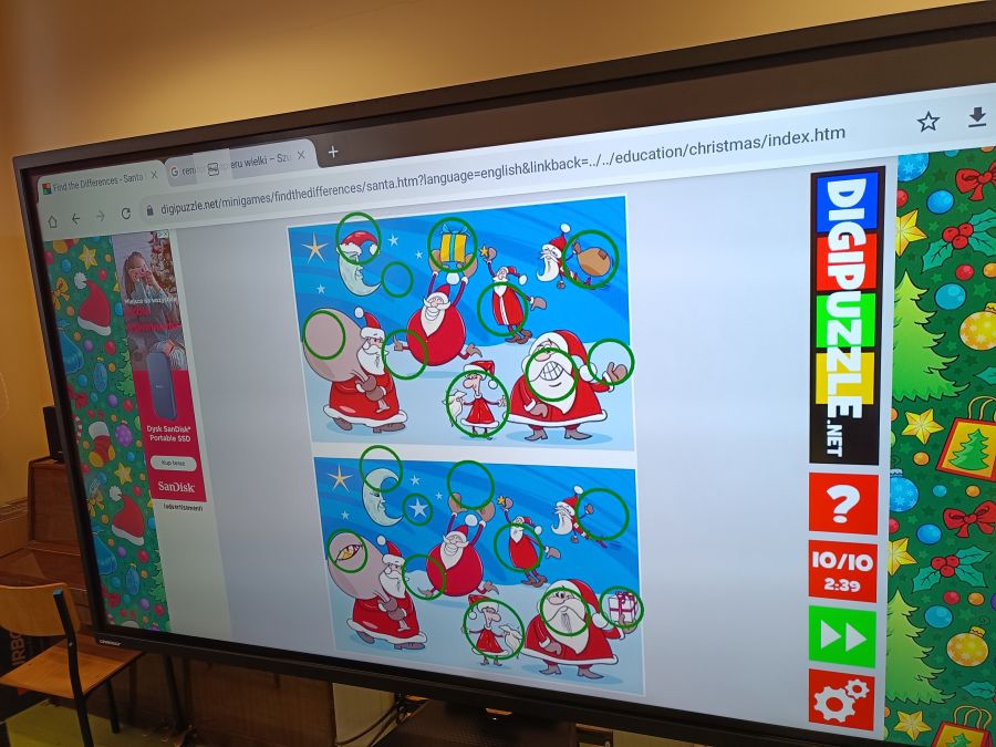 Ćwiczenie dotyczące znajdowania różnic między mikołajami na monitorze interaktywnym.