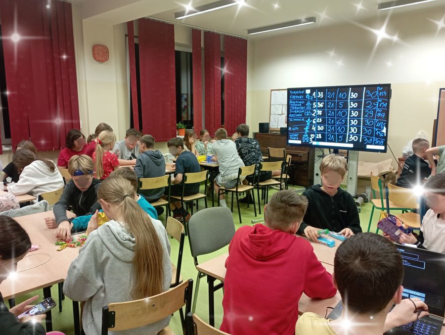 Uczestnicy konkursu siedzący w grupach przy stolikach