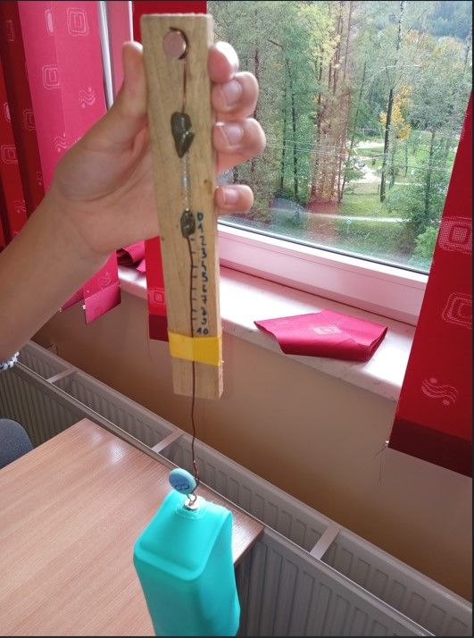 Piórnik zawieszony na skonstruowanym siłomierzu.