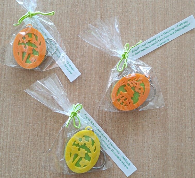 Breloczki w kształcie jajka z motywem wiosennym wydrukowane na drukarce 3D z bilecikiem z napisem Zespół Szkół Specjalnych w Skoczowie – Oddziały w Beskidzkim Zespole Leczniczo-Rehabilitacyjnym w Jaworzu.