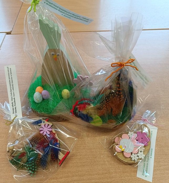 Ozdoby w kształcie kur i jajka wykonalne z drewna, kolorowych ozdobnych piór i filcu z bilecikiem z napisem Zespół Szkół Specjalnych w Skoczowie – Oddziały w Beskidzkim Zespole Leczniczo-Rehabilitacyjnym w Jaworzu.