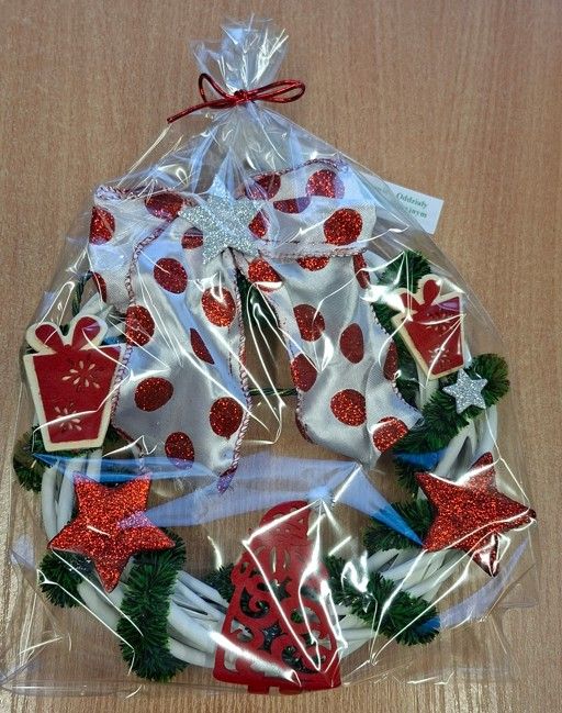 Ozdoba na kiermasz - wianek z łańcucha na choinkę, gwiazdek z brokatu, wstążki, drewnianych prezentów i Mikołaja z filcu - z bilecikiem z napisem Zespół Szkół Specjalnych w Skoczowie – Oddziały w Beskidzkim Zespole Leczniczo-Rehabilitacyjnym w Jaworzu.