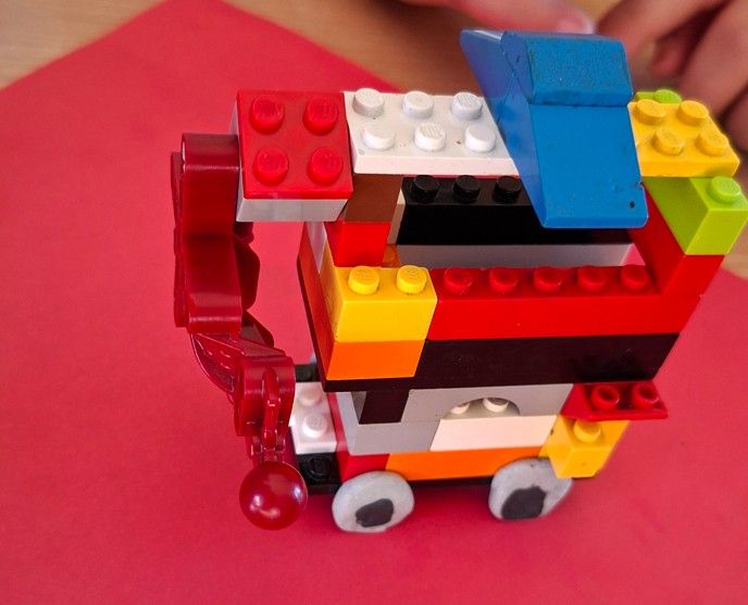 Ułożony pojazd z klocków LEGO z kołami z plasteliny.