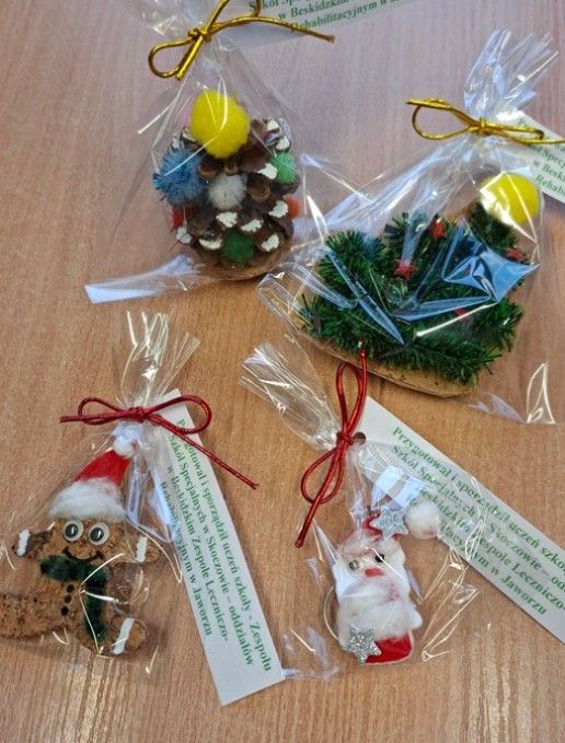 Wykonane ozdoby – upominki w ramach akcji mikołajkowej z szyszki i kolorowych pomponów - choinka, korka ściennego, zielonego łańcucha, pomponów i tkanin - magnesy w kształcie pierniczka i choinki oraz breloczek w kształcie Mikołaja wydrukowany na drukarce 3D - udekorowany filcem , watą i  gwiazdkami z brokatem - z bilecikami Przygotował i sporządził uczeń szkoły Zespołu Szkół Specjalnych w Skoczowie – Oddziałów w Beskidzkim Zespole Leczniczo-Rehabilitacyjnym w Jaworzu.