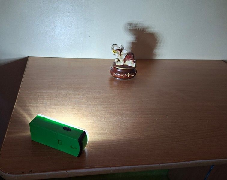 Zjawisko cienia - na ścianie oberwany cień figurki słonia.