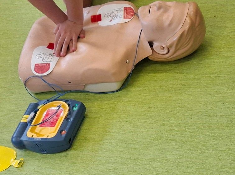 Wykonanie defibrylacji z wykorzystaniem automatycznego defibrylatora zewnętrznego (AED) na fantomie.